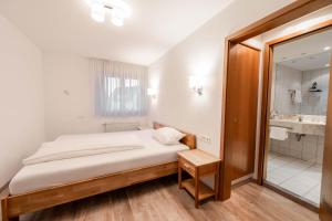 una piccola camera da letto con un letto e un bagno di Westend Hotel a Ludwigsburg