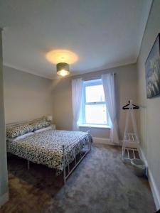 a bedroom with two beds and a window at large 4 bedroom in Pembroke Dock