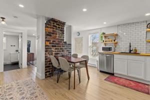 a kitchen and dining room with a table and a brick wall at Queen Top Suite 2BR Free Parking Modern in St. John's