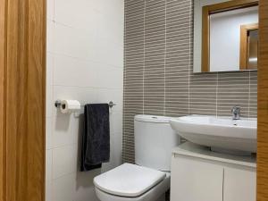 ein weißes Badezimmer mit Toilette und Waschbecken in der Unterkunft Sunrise Beach Apartment Playa Puerto de Sagunto in Puerto de Sagunto + 10 Fotos