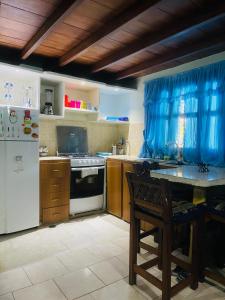 a kitchen with a refrigerator and a table in it at Cómodo town-house con piscina in El Marite