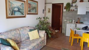 a living room with a couch and a kitchen at Appartamento in residence con piscina in Luino +14 photos