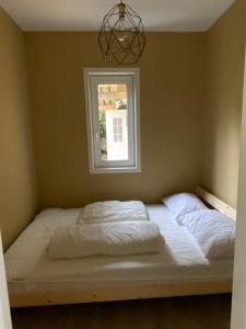 a bed in a room with a window at Leilighet i sentrum in Sokndal