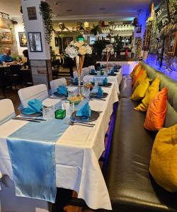 a row of tables in a restaurant with blue and white table settings at Brothers Perth City Centre in Perth