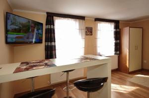 a kitchen with a white counter and a tv on the wall at Gyulai Brill Apartman in Gyula