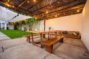 a patio with a wooden table and benches at Casa Tobala in Acapulco