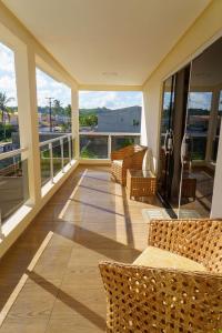 a balcony with wicker chairs and a view of the ocean at 4 quartos, sendo 2 suítes - uma com varanda privativa, a 700m da Praia da Boca da Barra e 2,5km da orla de Tamandaré, Wifi 200MB e cozinha completa - Piscina e estacionamento privativos - Ideal para grupos e famílias - tranquilo para home office in Tamandaré