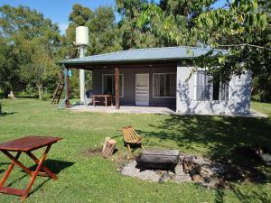 a cabin with a grill and a picnic table in a yard at Los Horneros in San Miguel del Monte