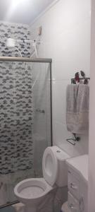 een badkamer met toilet en glazen douche bij Hospedaria Dona Clara in Tiradentes