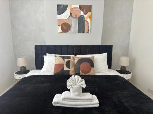 ein Schlafzimmer mit einem Bett mit einer schwarzen Decke in der Unterkunft 4 Bed Home Northampton, FreeParking, Superfast WiFi, 5TVs in Northampton + 21 Fotos