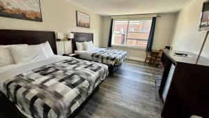 ein Hotelzimmer mit zwei Betten und einem Flachbildfernseher in der Unterkunft Town Centre Inn - Parry Sound in Parry Sound