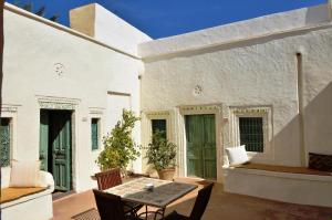a patio with a table and chairs next to a building at Hotel Dar Dhiafa in Houmt Souk