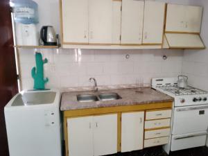 a small kitchen with a sink and a stove at El Refugio House in Maipú