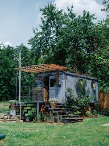an old caravan with a roof and stairs in a yard at Ubytování Maringote in Doubravice