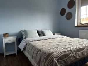 a bedroom with a bed and a window at Apartament Lubię Błękit in Rowy