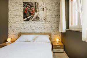 a bedroom with a white bed and a brick wall at VillaTota in Umag +46 photos