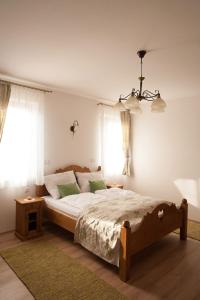 a bedroom with a large bed and a chandelier at Maushaus in Véménd