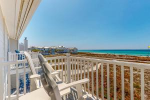 a balcony with two chairs and the beach at Beach Bahr Den in Santa Rosa Beach