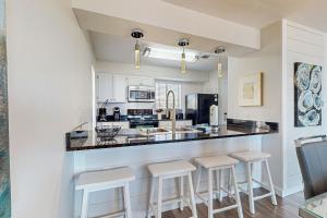 a kitchen with a counter and stools at a bar at Beach Bahr Den in Santa Rosa Beach +10 photos