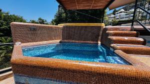 a swimming pool with a bench and a tub at Casa Jade in Acapulco