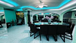 a dining room with a table and black chairs at Casa Jade in Acapulco