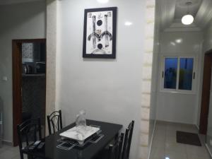 a dining room with a black table and chairs at S I Appartements in Dakar