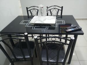 a black table with two chairs and a remote control at S I Appartements in Dakar +55 photos