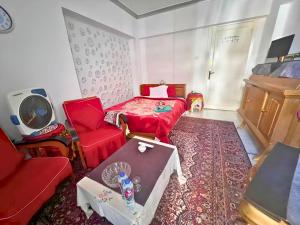 a room with a bed and a couch and a table at Gadou Rooms in Port Said