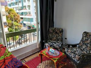 a room with two chairs and a table and a window at Gadou Rooms in Port Said