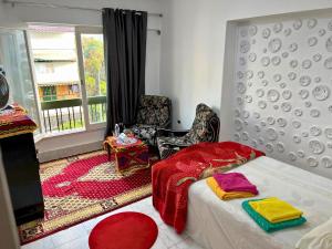 a bedroom with a bed and a chair and a window at Gadou Rooms in Port Said