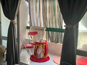 a room with a red chair and a window at Gadou Rooms -Private & Shared Stays in Port Said Best Location in Port Said