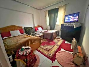 a bedroom with two beds and a flat screen tv at Gadou Rooms -Private & Shared Stays in Port Said Best Location in Port Said