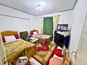 a room with two beds and a television in it at Gadou Rooms -Private & Shared Stays in Port Said Best Location in Port Said