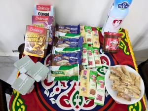 a table topped with snacks and a plate of food at Gadou Rooms -Private & Shared Stays in Port Said Best Location in Port Said