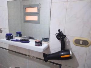 a bathroom with a sink and a mirror at Gadou Rooms -Private & Shared Stays in Port Said Best Location in Port Said