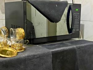 a microwave oven sitting on a counter with gold items at Gadou Rooms -Private & Shared Stays in Port Said Best Location in Port Said