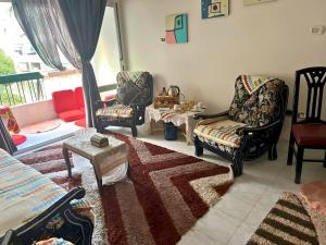 a living room with two chairs and a table at Gadou Rooms -Private & Shared Stays in Port Said Best Location in Port Said