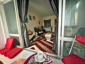 a living room with red chairs and a large window at Gadou Rooms -Private & Shared Stays in Port Said Best Location in Port Said