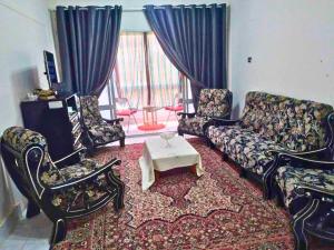 a living room with a couch and chairs and a table at Gadou Rooms -Private & Shared Stays in Port Said Best Location in Port Said