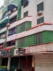 a green and white building with a sign in front of it at Gadou Rooms -Private & Shared Stays in Port Said Best Location in Port Said