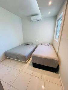 Dos camas en una habitación pequeña con ventana. en San Angel, en Topilejo