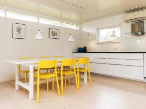 a kitchen with a table and yellow chairs at 6 person holiday home in Gilleleje-By Traum in Gilleleje