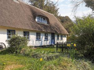 a house with a thatched roof with a bench in front at 6 person holiday home in Søby Ærø-By Traum in Leby