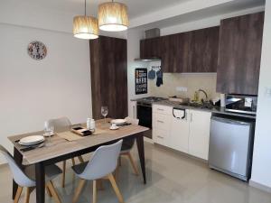 una cocina con una mesa y sillas de madera y una mesa y una cocina con en santiago18, en San Juan