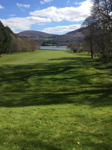 un grande prato con un lago sullo sfondo di Golf Course View a Kenmare Altre 12 foto