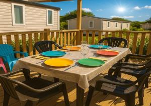 a table with plates and wine glasses on a deck at LUXURY Eden 55m2 Fun pass exclus in Canet-en-Roussillon