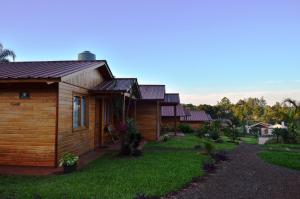a wooden house with a grass yard next to it at Cabañas Doralia in Oberá