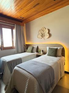 a bedroom with two beds and a flower on the wall at Villa Prime Beach Flats in Aracaju +34 photos