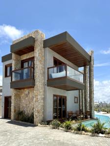 a house with a balcony and a swimming pool at Villa Prime Beach Flats in Aracaju