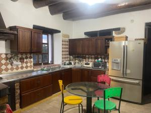 une cuisine avec une table, des chaises et un réfrigérateur dans l'établissement Villa Country Colonial Socorro Santander, à Socorro